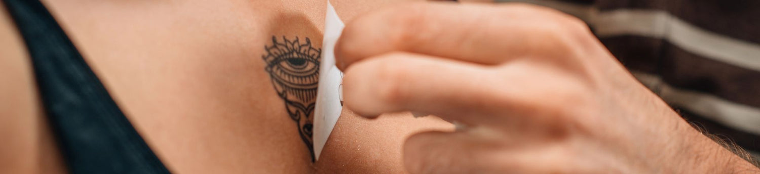 a woman removing her temporary tattoo in her chest