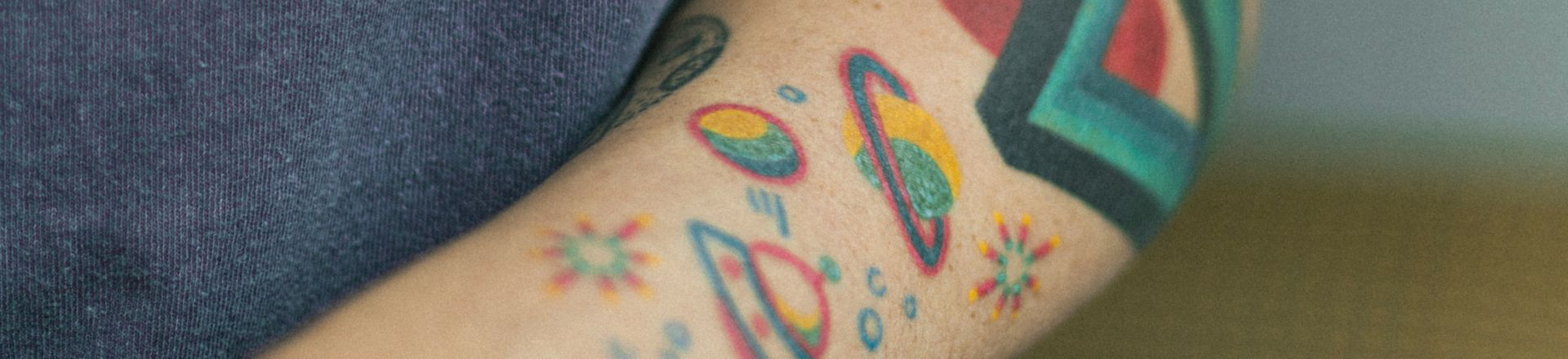 A man displaying a Temp Tattoo For Sale'design on his arm