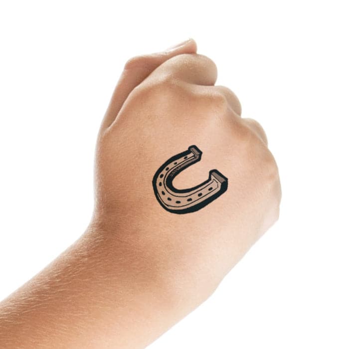Tiny micro-realistic horseshoe tattoo located on the